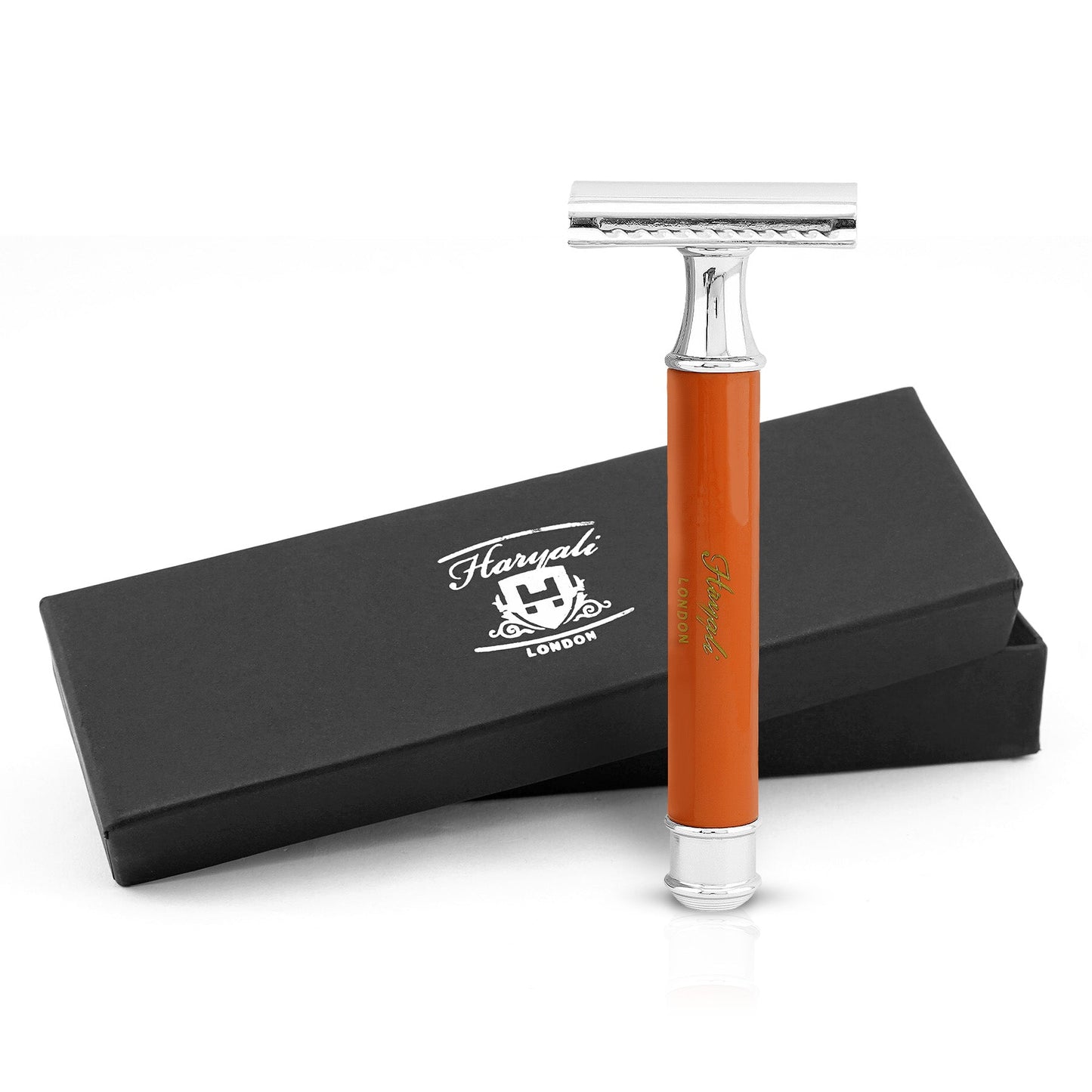 A safety razor with an orange handle displayed alongside its black packaging box with 'Haryali London' branding.