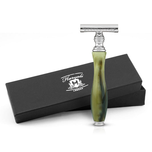 A safety razor with a green and black handle, resembling tortoise horn, alongside its black box packaging with the Haryali London logo.